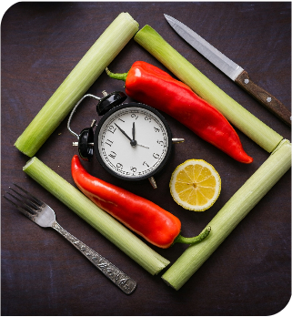 Lauch mit Paprika im Quadrat um einen Wecker gelegt