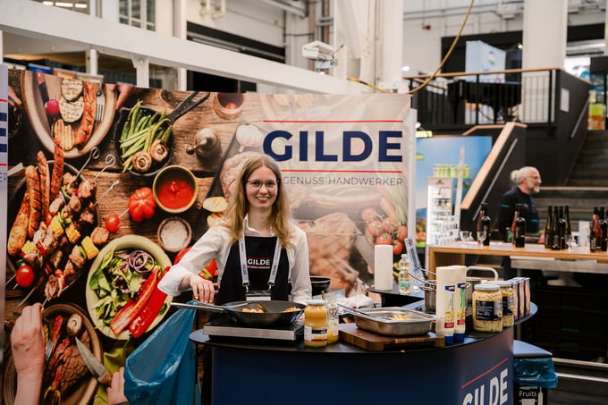 Eine Mitarbeiterin der GILDE am GILDE Eigenmarken-Stand auf der TRIALOGE